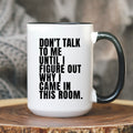 White mug with black handle and 'PERIMENOPAUSAL.' text on a wooden surface.
